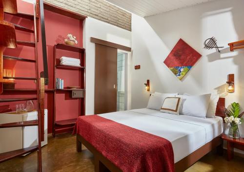 1 dormitorio con cama blanca y estante rojo en Samba do Kite Pousada, en Jericoacoara