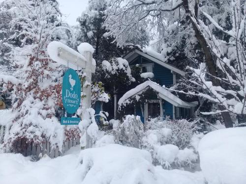 a sign in the snow in front of a house at Dodo House in Villa La Angostura
