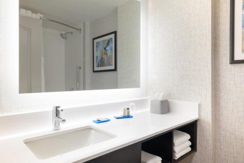 Baño blanco con lavabo y espejo en Holiday Inn Express & Suites Boston - Cambridge, an IHG Hotel, en Cambridge