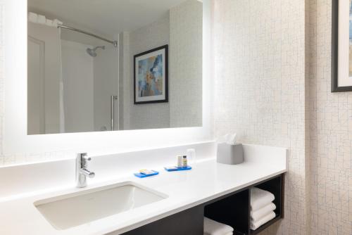 a white bathroom with a sink and a mirror at Holiday Inn Express & Suites Boston - Cambridge by IHG in Cambridge