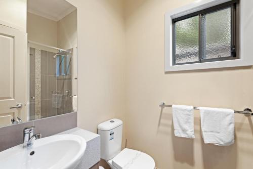 a bathroom with a sink and a toilet and a window at Discovery Parks - Lake Hume, Victoria in Bonegilla