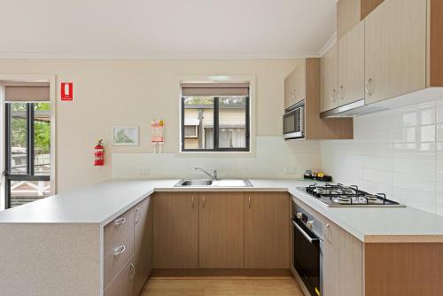 a kitchen with a sink and a stove top oven at Discovery Parks - Lake Hume, Victoria in Bonegilla