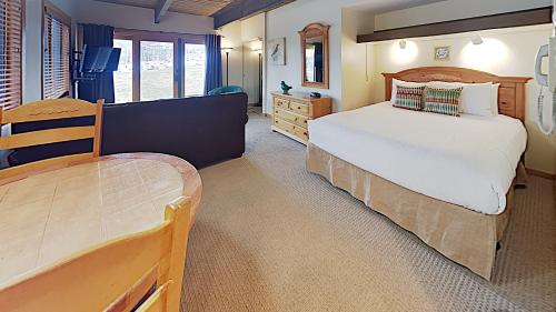 ein Schlafzimmer mit einem Bett und einem Stuhl darin in der Unterkunft Timberline Condominiums Studio Standard Unit 118 in Snowmass Village