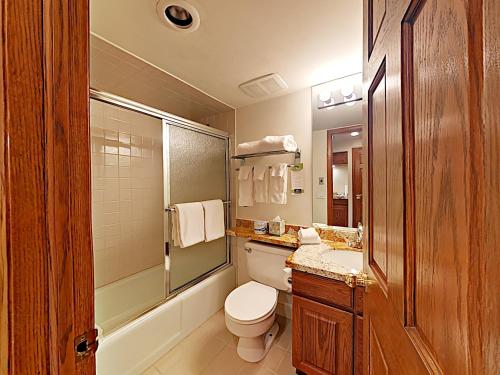 a bathroom with a toilet and a sink and a mirror at Timberline Condominiums Studio Deluxe Unit 214 in Snowmass Village