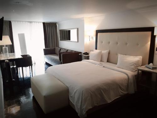 um quarto de hotel com uma cama grande e um sofá em SUITES LONDRES 212 em Cidade do México