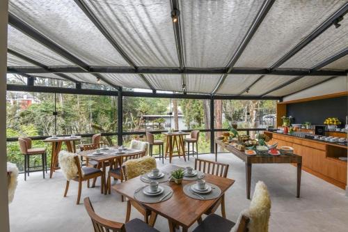 un patio con mesas y sillas y una cocina. en Villa Amistà Campos do Jordão, en Campos do Jordão