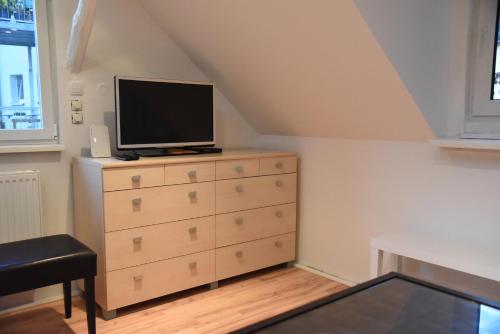 a bedroom with a dresser with a television on it at Gästehaus pack of patches in Jena