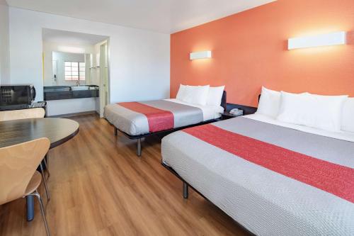 a hotel room with two beds and a table at Motel 6-Thousand Oaks, CA in Thousand Oaks