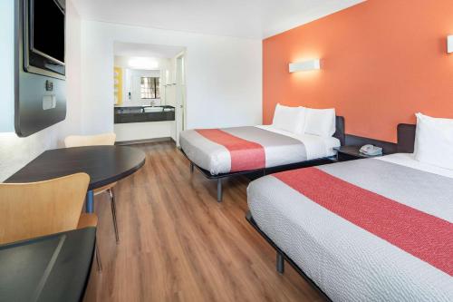 a hotel room with two beds and a table at Motel 6-Thousand Oaks, CA in Thousand Oaks