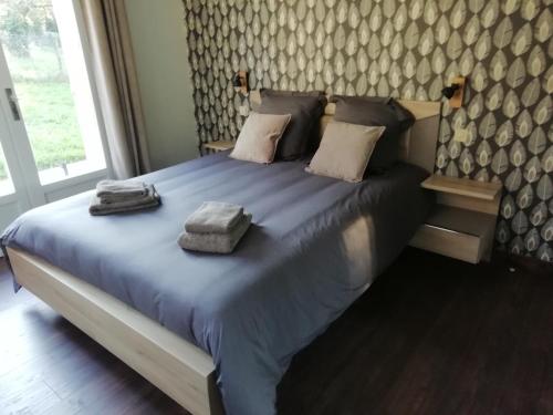 een slaapkamer met een groot bed en 2 handdoeken bij Le Relais du Mulberry in Lantheuil