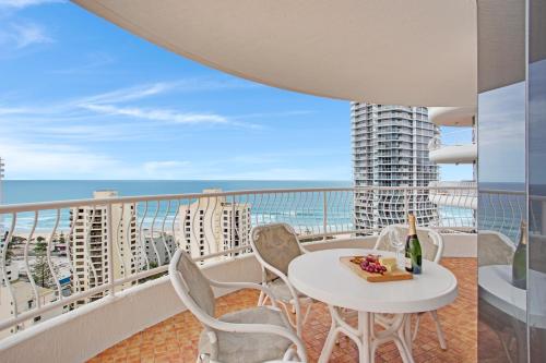 a balcony with a table and chairs and the ocean at Aegean Apartments Surfers Paradise in Gold Coast