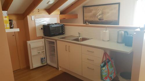 a small kitchen with a sink and a microwave at Loft on copley in Lenah Valley