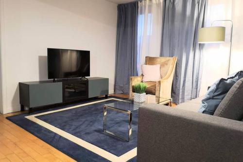 a living room with a flat screen tv and a couch at Chez Edouard by Hébergements DCL in Quebec City