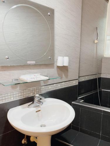 a bathroom with a sink and a mirror at H Hotel in Taipei