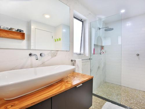 a bathroom with a white sink and a shower at Arklow I Pet Friendly with Ocean Views in Culburra Beach