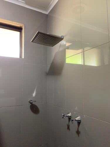 a bathroom with a shower with a glass wall at Federation Motel Resort - Corowa in Corowa