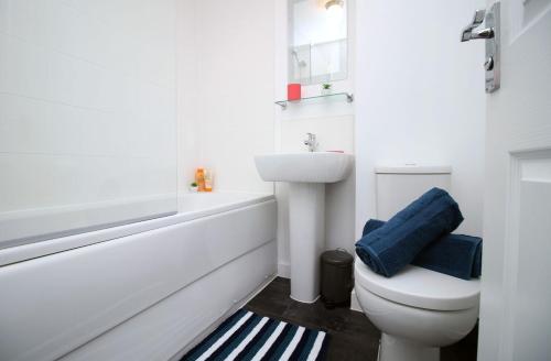 a white bathroom with a toilet and a sink at No1 Marina Walk by Stay South Wales -FREE Parking in Swansea