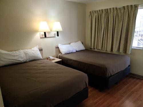 a hotel room with two beds and a window at Motel 9 Las Cruces in Las Cruces