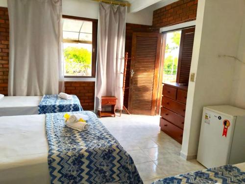 a bedroom with two beds and a dresser at Pousada Luz do Porto in Porto De Galinhas