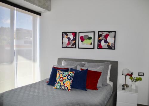 sypialnia z łóżkiem z czterema obrazami na ścianie w obiekcie Cozy Stays Cayala Apartments 2 w mieście Gwatemala