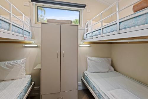 a small room with two bunk beds and a window at Discovery Parks - Lake Hume, Victoria in Bonegilla