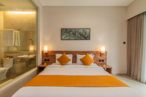 a bedroom with a large bed and a bathroom at D Home Seminyak by Pramana Villas in Seminyak