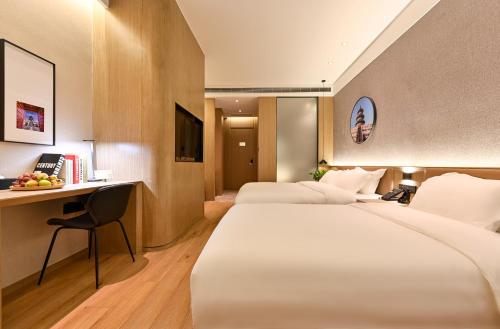 北京市にある行舍酒店北京天安门广场天坛店のベッド2台とデスクが備わるホテルルームです。