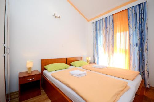 a bedroom with two beds and a window at Apartments and Rooms Stipe in Podstrana