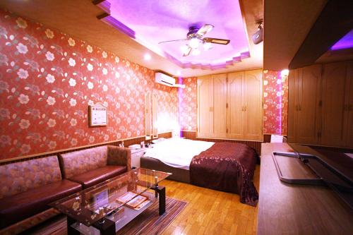 a bedroom with a bed and a couch in a room at Hotel Ohirune Racco Sakai (Adult Only ) in Sakai