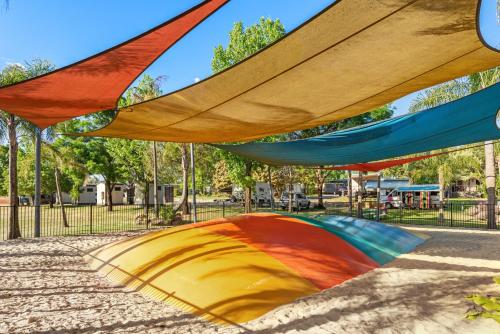 a group of colorful umbrellas in a park at Discovery Parks - Lake Hume, Victoria in Bonegilla