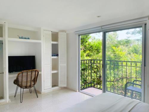 een slaapkamer met een bed, een tv en een balkon bij Villa Antilope in Cancun