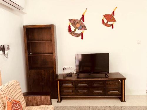 a living room with a flat screen tv on a wall at Kerteh Apartment in Kertih