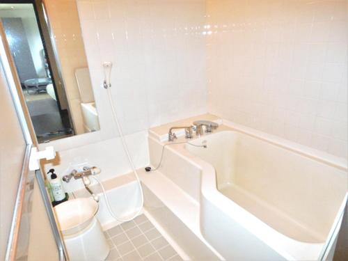 un bagno con vasca, WC e lavandino di J-Garden a Ito