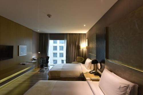 Un pat sau paturi într-o cameră la Holiday Inn New Delhi International Airport, an IHG Hotel