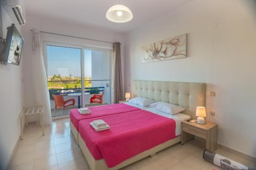 a bedroom with a large bed with a pink blanket at Villa Maroula in Afantou