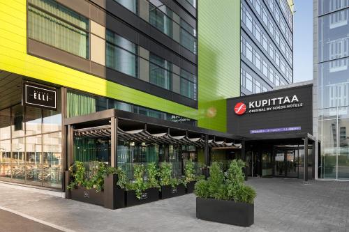 a store front of a building with potted plants in front at Original Sokos Hotel Kupittaa in Turku