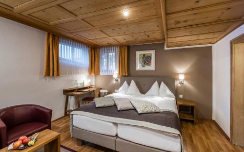 um quarto com uma cama grande e uma cadeira em Hotel Stern Chur em Chur