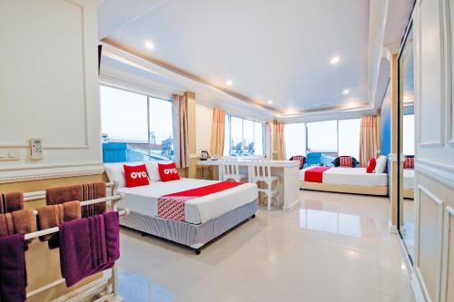 a bedroom with two beds and a table and chairs at OYO 1117 Phuket Airport Suites in Nai Yang Beach