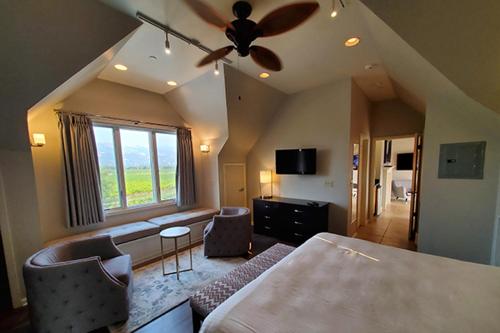 a bedroom with a ceiling fan and a living room at Geyserville Inn in Geyserville