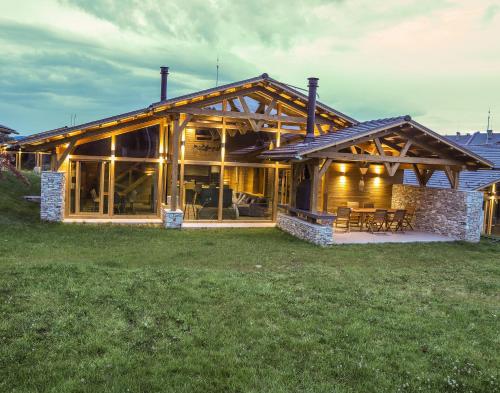 a large wooden house with a table and chairs at Mountain Hawk Park in Bansko
