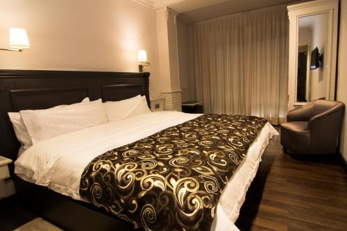 ベラにあるAvent Verahotelのベッドと椅子付きのホテルルーム
