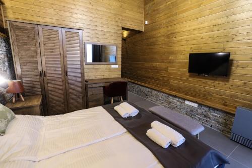 a bedroom with a bed and a flat screen tv at Mountain Hawk Park in Bansko