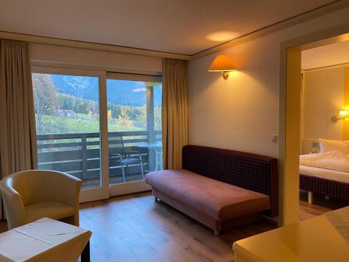 a hotel room with a bed and a large window at Hotel Belmont in Imst