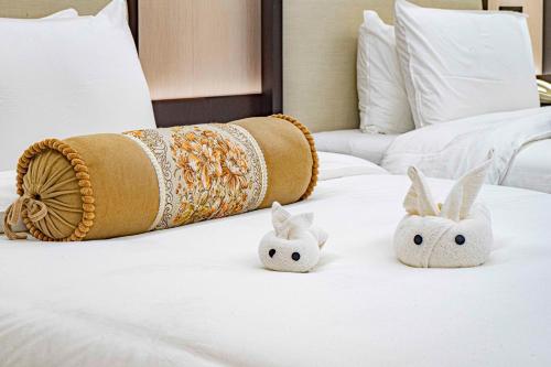 two white bunny pillows on a bed at Guangdong Hotel-Free Shuttle & Registration Counter Service during Canton Fair in Guangzhou