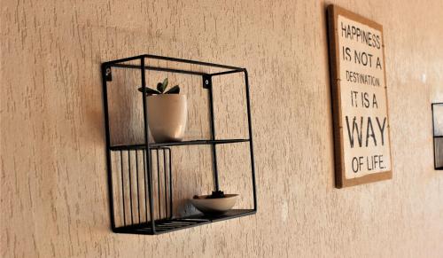a black shelf with a potted plant on a wall at Studio sous les pistes avec vue sur la vallée in La Bresse