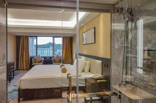 広州市にあるGuangdong Hotel-Free Shuttle & Registration Counter Service during Canton Fairのホテルルーム(ベッド1台、ガラス張りのシャワー付)