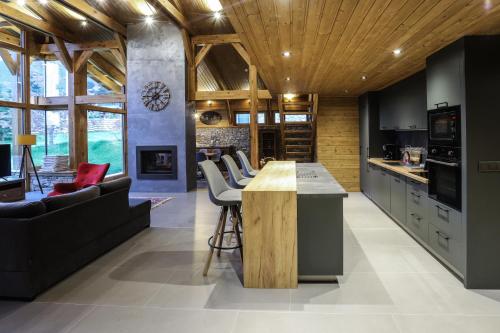 a kitchen with a wooden ceiling and a living room at Mountain Hawk Park in Bansko