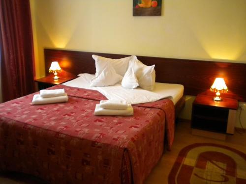 a hotel room with a bed with towels on it at Hotel Decebal in Braşov