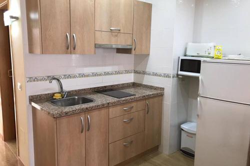 a small kitchen with a sink and a refrigerator at Toplage. Blick. Sauber. Günstig. Pool. Gepflegt in Puerto de la Cruz