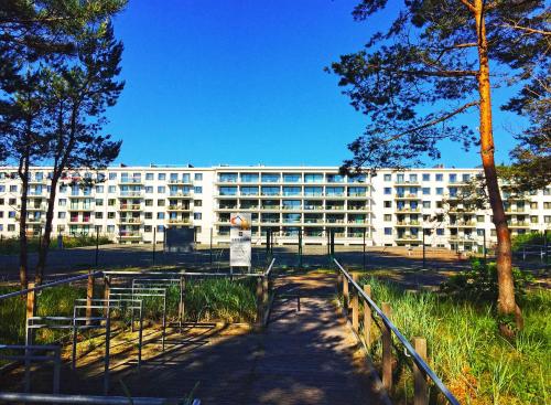 um grande edifício branco com árvores em frente em Strandresort Prora - WG 201 mit Meerblick und IR-Sauna em Binz